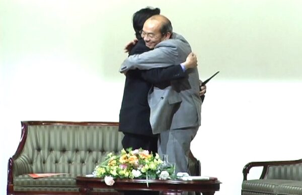 西田文郎先生と清水克衛さんの対談講演終了で抱き合い称え合う様子